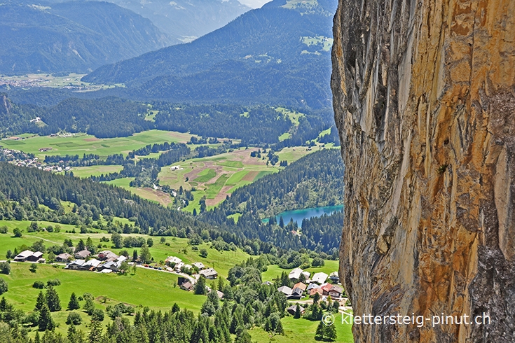 Ausblick vorbei am Meilerstein hinuner auf den Crestasee